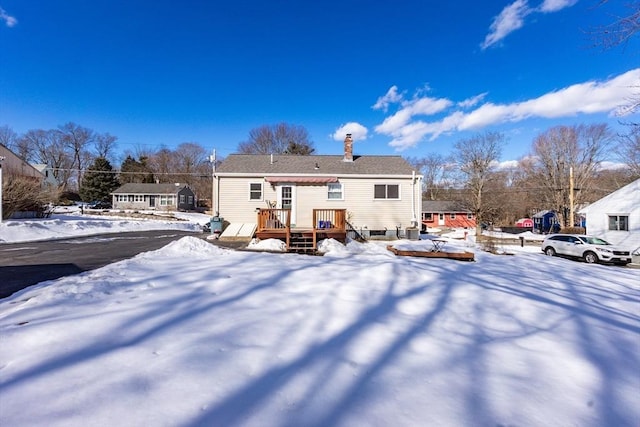 snow covered property featuring a chimney