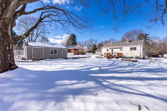 yard covered in snow featuring an outbuilding