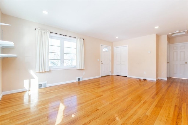 unfurnished living room with baseboards, visible vents, and light wood finished floors