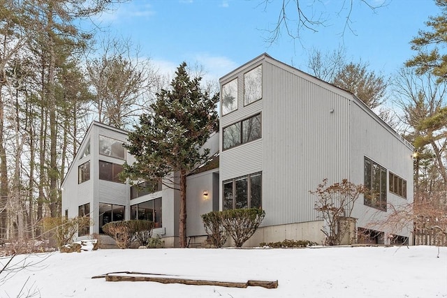 view of snowy exterior with a sunroom