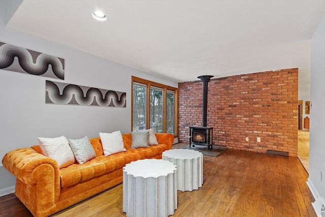 living room featuring wood-type flooring and a wood stove