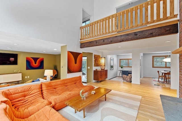 living room with light hardwood / wood-style floors and a high ceiling