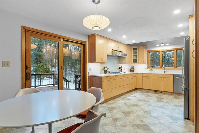 kitchen with backsplash, sink, light brown cabinetry, decorative light fixtures, and stainless steel appliances