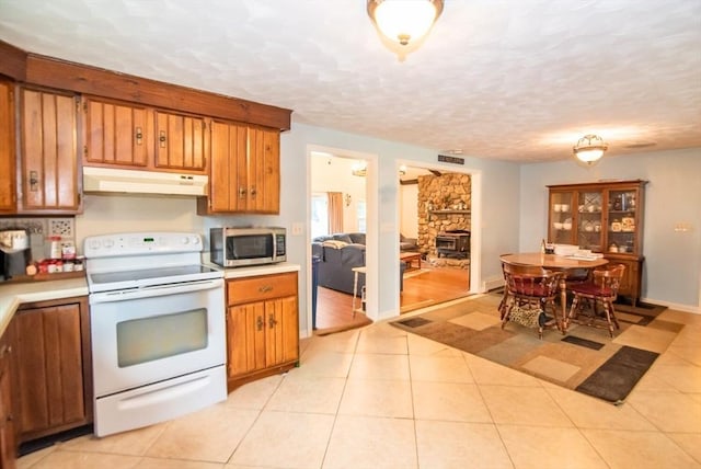 95 N Lowell St, Methuen, MA 01844 - kitchen featuring white electric range, under cabinet range hood, stainless steel microwave, brown cabinets, and light countertops