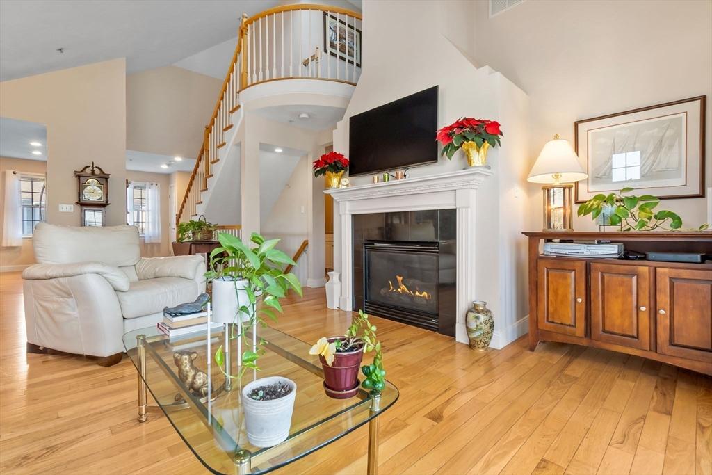 living room featuring a fireplace, a high ceiling, and light hardwood / wood-style flooring