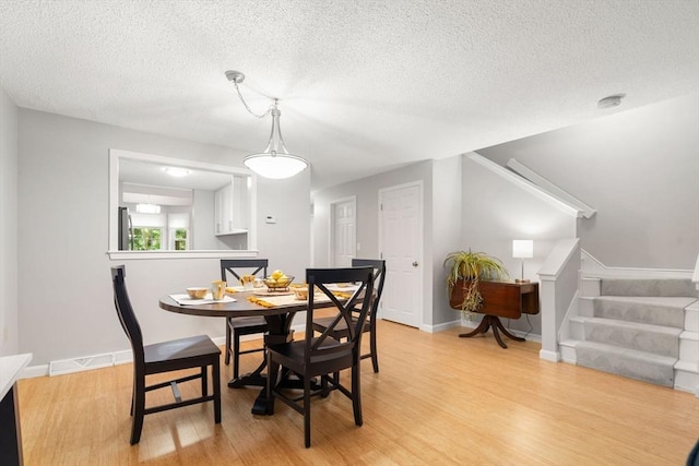 20 Hawthorne Vlg Unit C, Franklin, MA 02038 - dining area with light wood-style floors, stairs, and a textured ceiling
