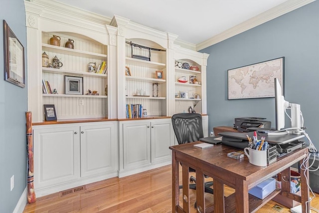 office space with visible vents, ornamental molding, and light wood finished floors