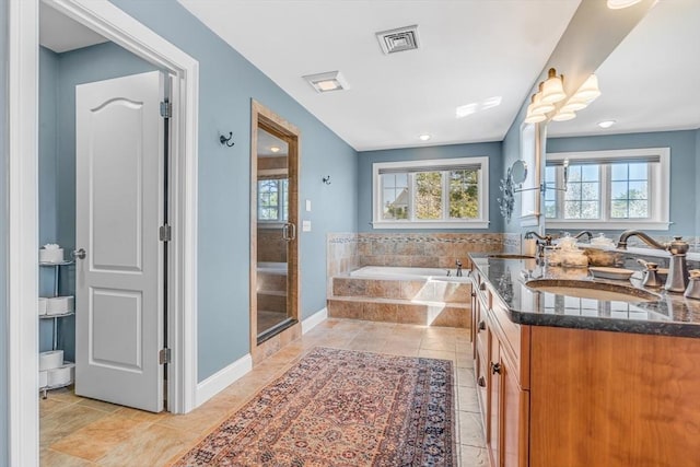 bathroom with double vanity, a bath, visible vents, a stall shower, and a sink