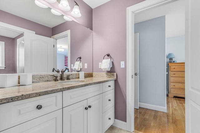 bathroom with baseboards, vanity, and wood finished floors