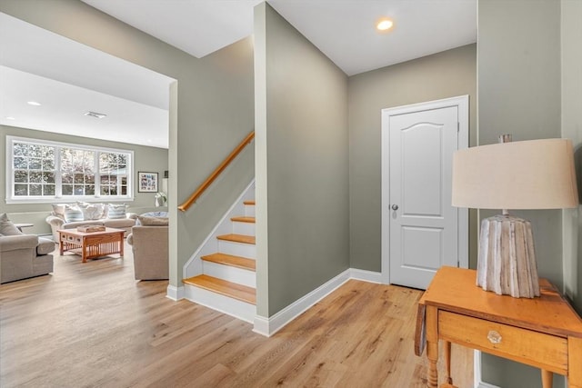 stairway with baseboards, recessed lighting, wood finished floors, and visible vents