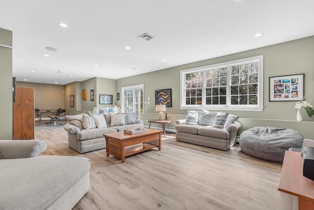 living room with recessed lighting, visible vents, and light wood-type flooring