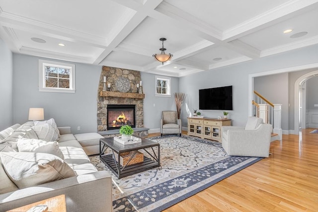 living room featuring plenty of natural light, arched walkways, coffered ceiling, and wood finished floors