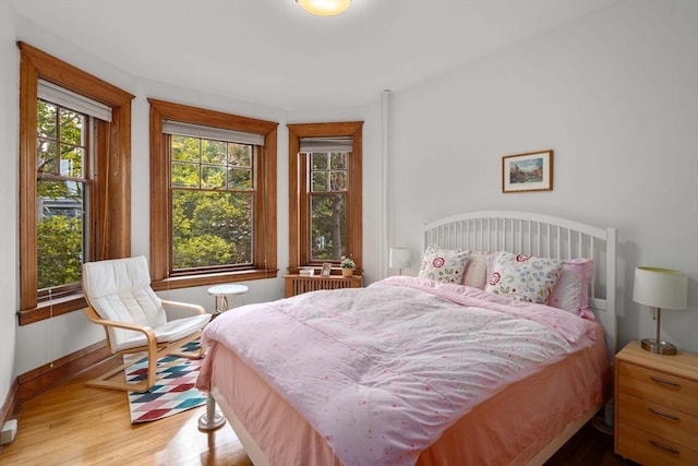 bedroom featuring hardwood / wood-style flooring and radiator heating unit