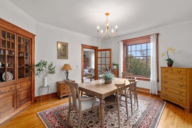 dining area featuring light hardwood / wood-style floors, an inviting chandelier, and ornamental molding