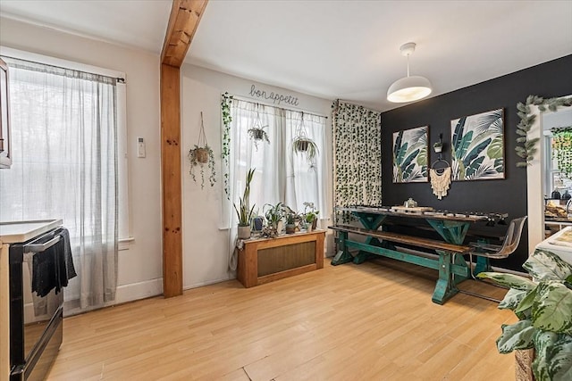 living area with beam ceiling and hardwood / wood-style floors