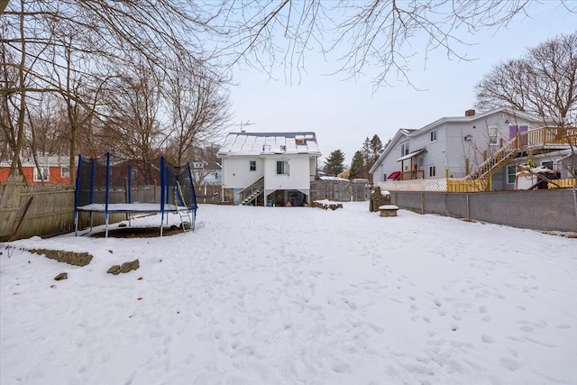 snow covered house with a trampoline