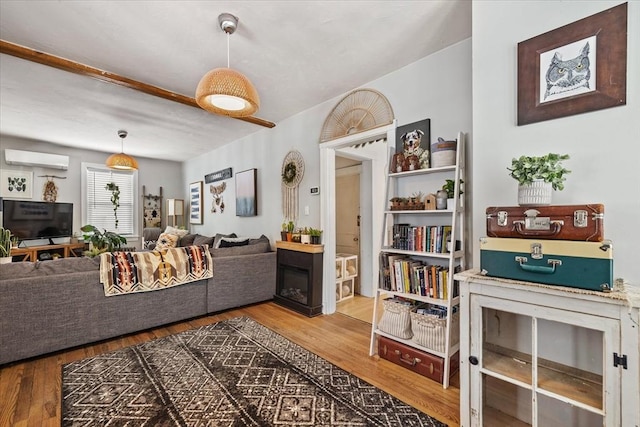 living room with wood-type flooring and an AC wall unit