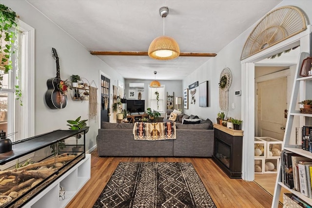 living room with a wall unit AC and light wood-type flooring