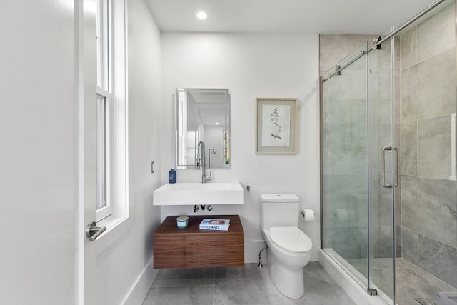 bathroom featuring tile patterned floors, sink, toilet, and a shower with shower door