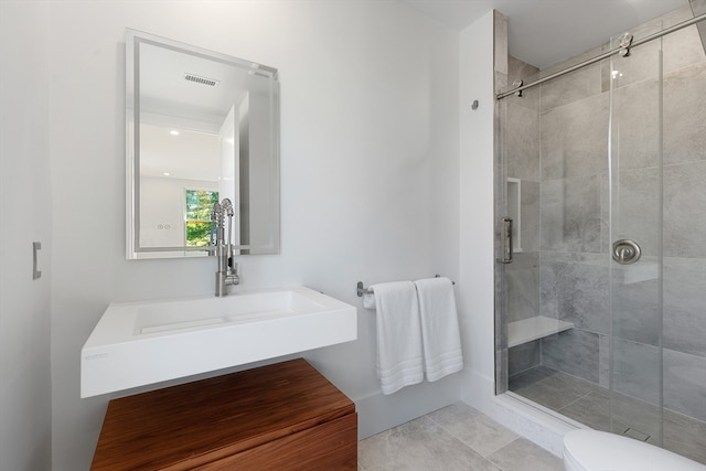 bathroom with toilet, tile patterned floors, and a shower with shower door