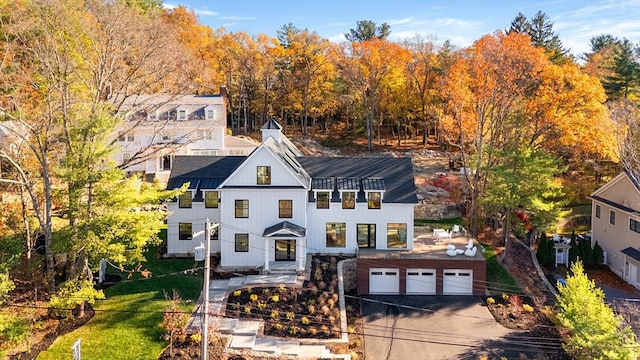 modern inspired farmhouse with an outbuilding, a garage, and a front lawn