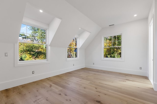 additional living space with plenty of natural light, light hardwood / wood-style flooring, and lofted ceiling