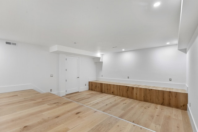 basement with light hardwood / wood-style flooring