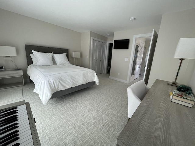 bedroom with light colored carpet, a closet, and baseboards