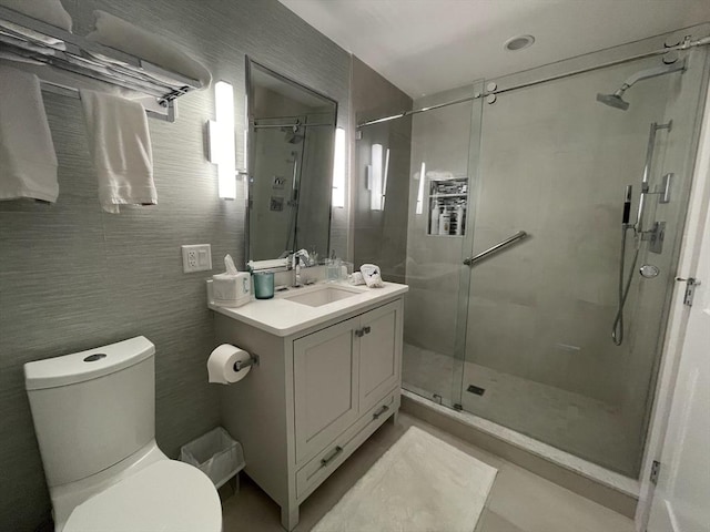 bathroom featuring toilet, vanity, and a shower stall