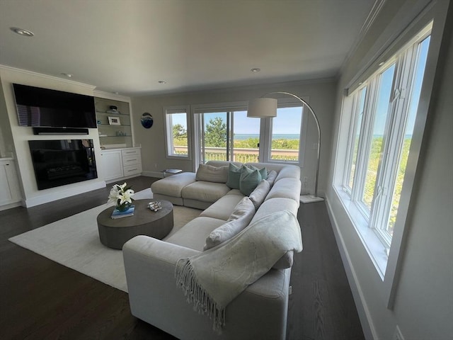 living room with ornamental molding, recessed lighting, dark wood finished floors, baseboards, and a glass covered fireplace