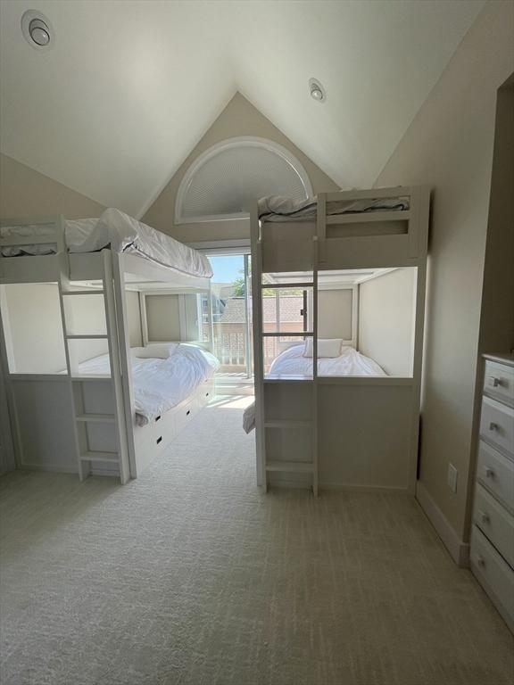 unfurnished bedroom with vaulted ceiling, access to outside, and carpet floors
