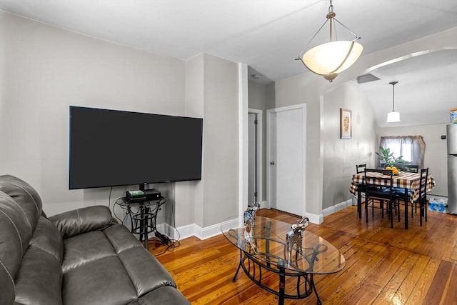 living room featuring wood-type flooring and vaulted ceiling