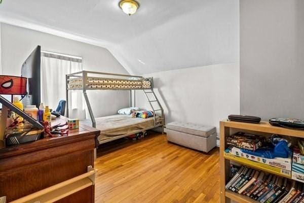 bedroom featuring wood-type flooring and vaulted ceiling