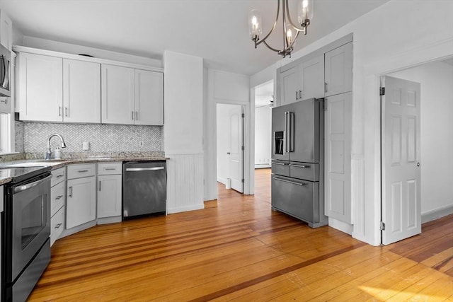 kitchen featuring hanging light fixtures, tasteful backsplash, appliances with stainless steel finishes, and white cabinetry