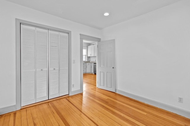 unfurnished bedroom featuring light wood-type flooring and a closet