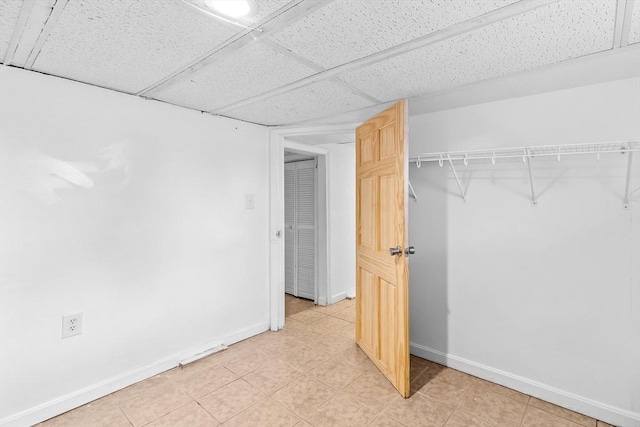 interior space featuring a paneled ceiling and a closet