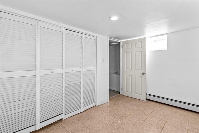 unfurnished bedroom with a closet and baseboard heating