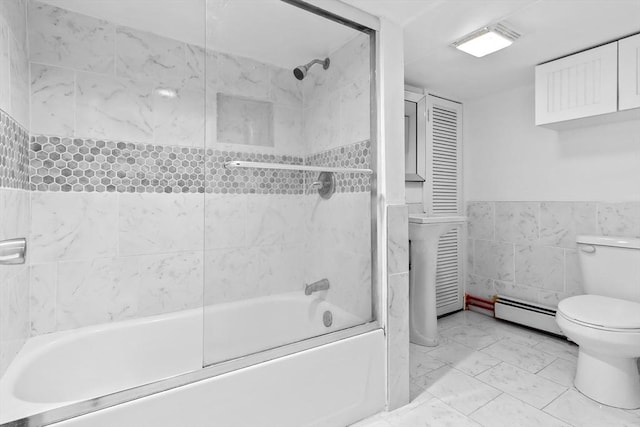 bathroom featuring tile walls, a baseboard radiator, toilet, and combined bath / shower with glass door