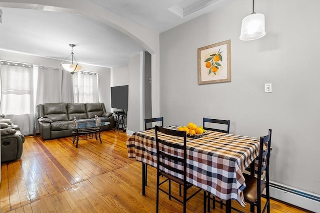 dining area with a baseboard radiator and hardwood / wood-style floors