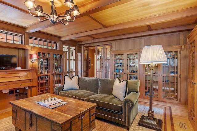 23 Newmarch St, Ipswich, MA 01938 - living area with wood ceiling, a chandelier, wood walls, beamed ceiling, and light wood-style flooring