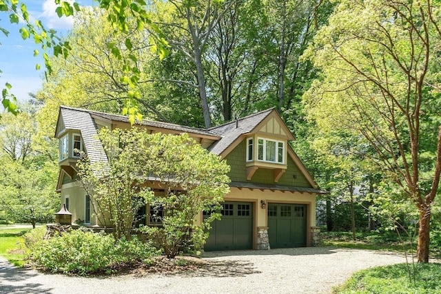 23 Newmarch St, Ipswich, MA 01938 - view of front of home featuring driveway, a garage, and stone siding
