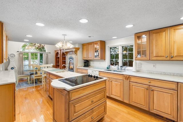 11 Bayside Dr, Wales, MA 01081 - kitchen with black electric stovetop, a center island with sink, a sink, a textured ceiling, and plenty of natural light