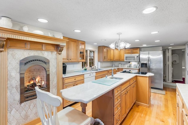 11 Bayside Dr, Wales, MA 01081 - kitchen with white appliances, light countertops, a sink, a chandelier, and a center island with sink