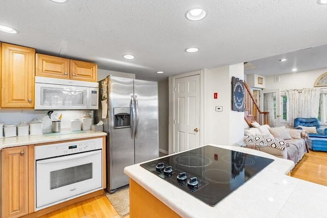 11 Bayside Dr, Wales, MA 01081 - kitchen with white appliances, a textured ceiling, open floor plan, light wood-type flooring, and light countertops