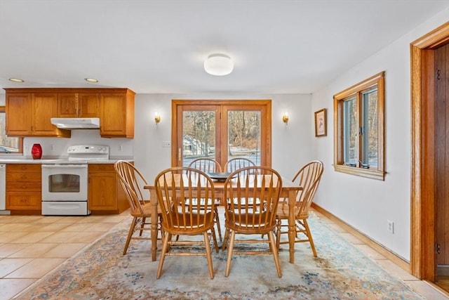 tiled dining space featuring a healthy amount of sunlight