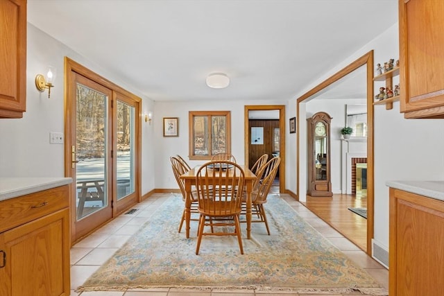 tiled dining space with a brick fireplace