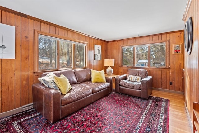 living room with wooden walls and light hardwood / wood-style floors