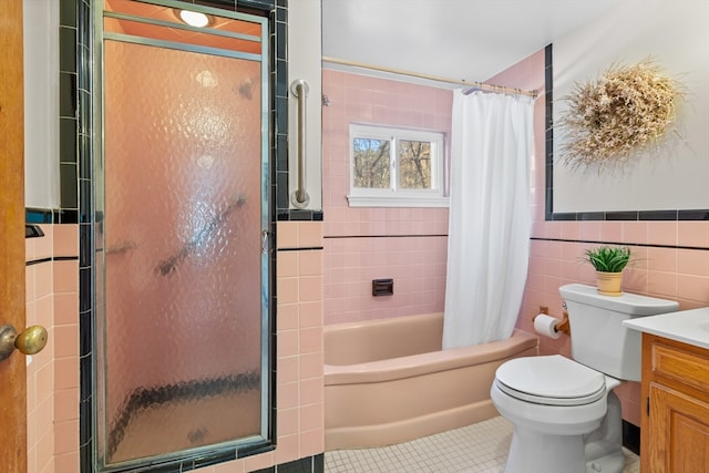 bathroom featuring tile patterned floors, toilet, tile walls, and vanity