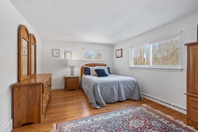 bedroom featuring baseboard heating and light hardwood / wood-style floors