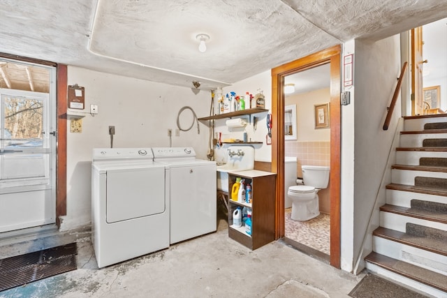 laundry room with washing machine and dryer and tile walls